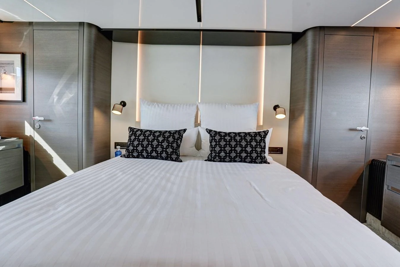 The stateroom features a luxurious bed with elegant lighting and modern decor. aboard APRICITY Yacht for Sale
