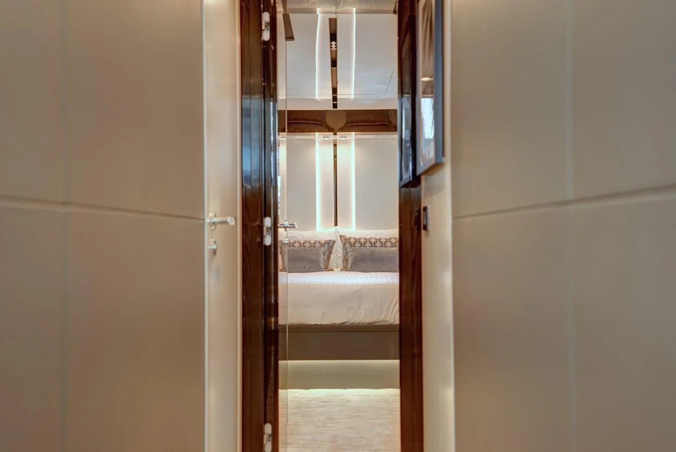 A view down a hallway leading to a luxurious stateroom with elegant lighting and decor. aboard APRICITY Yacht for Sale
