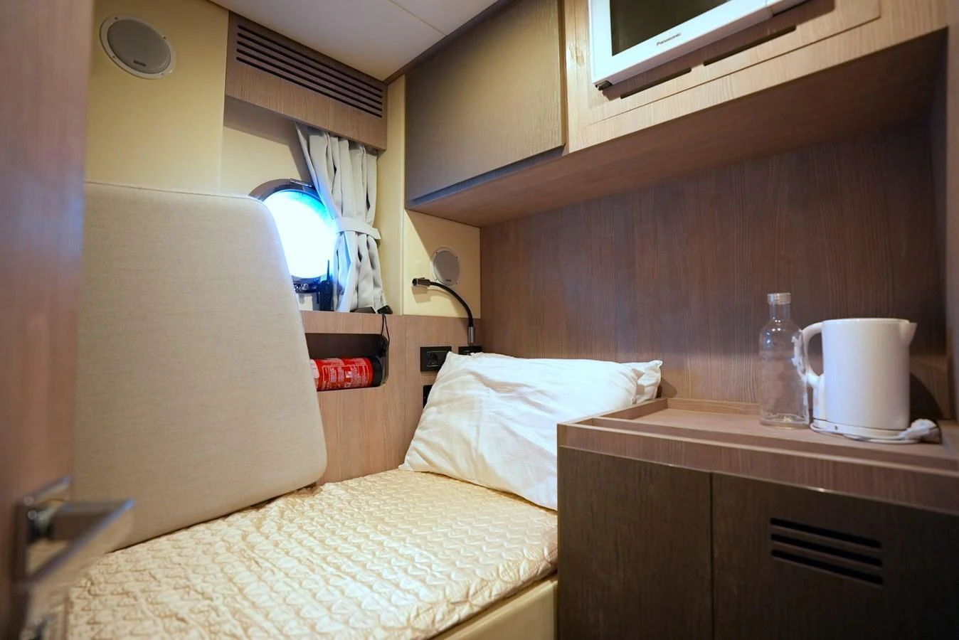A cozy crew cabin featuring a single bed, a small window, and essential amenities. aboard APRICITY Yacht for Sale