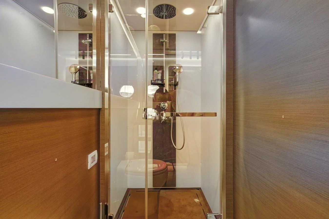 A modern yacht bathroom with a glass-enclosed shower and sleek wooden finishes. aboard APRICITY Yacht for Sale