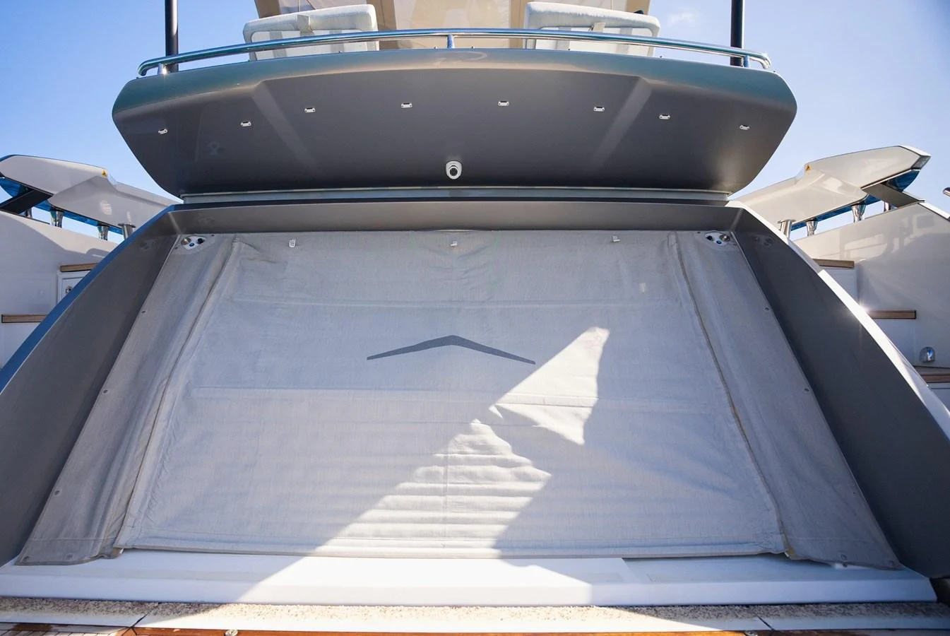 The image showcases the aft section of a yacht with a partially open garage door, revealing a spacious storage area. aboard APRICITY Yacht for Sale