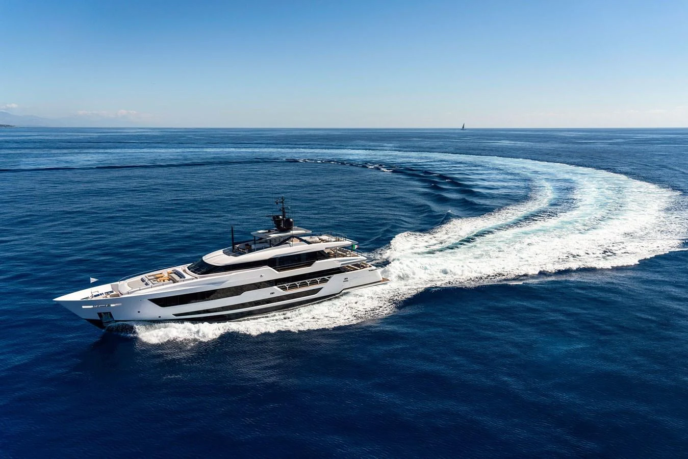 A sleek yacht cruises through the open sea, leaving a trail of white wake behind. aboard MIOTU Yacht for Sale