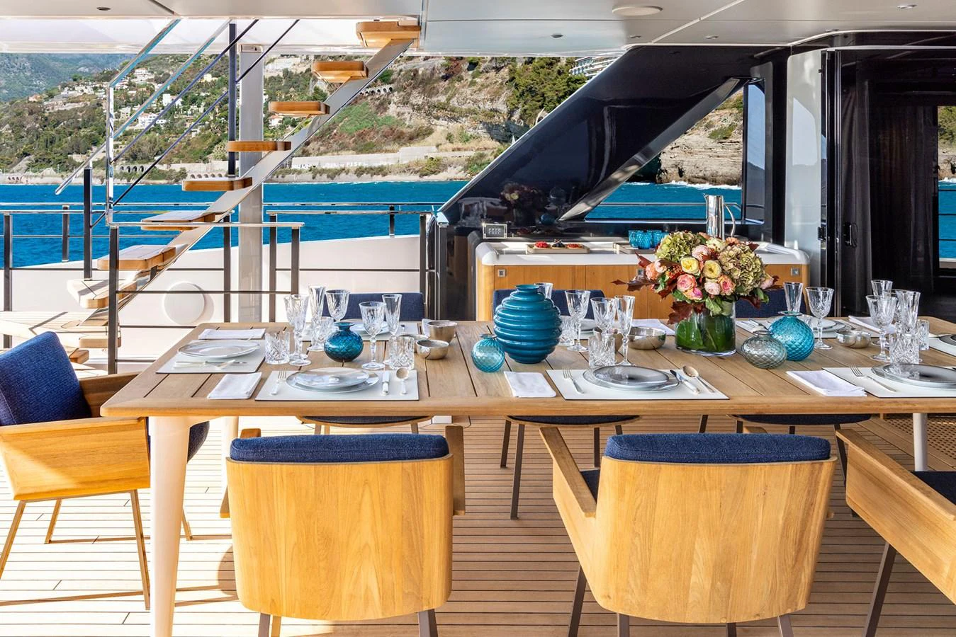 The aft deck features a beautifully set dining table with a stunning ocean view. aboard MIOTU Yacht for Sale