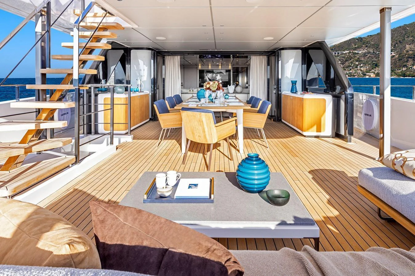 The aft deck features a spacious and stylish seating area with a dining table, perfect for outdoor relaxation and meals. aboard MIOTU Yacht for Sale