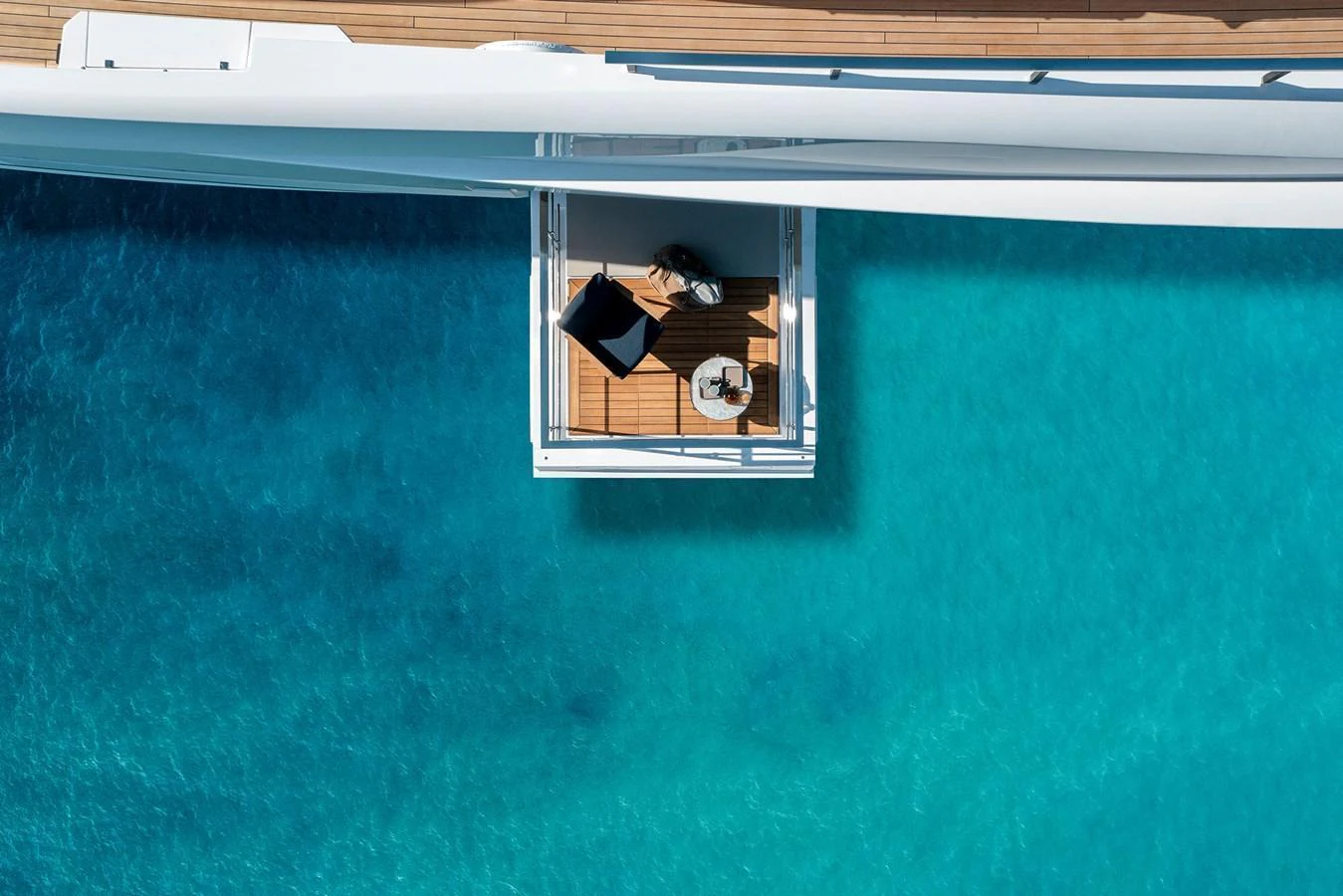 A serene private balcony extends over crystal-clear turquoise waters, offering a perfect spot for relaxation. aboard MIOTU Yacht for Sale