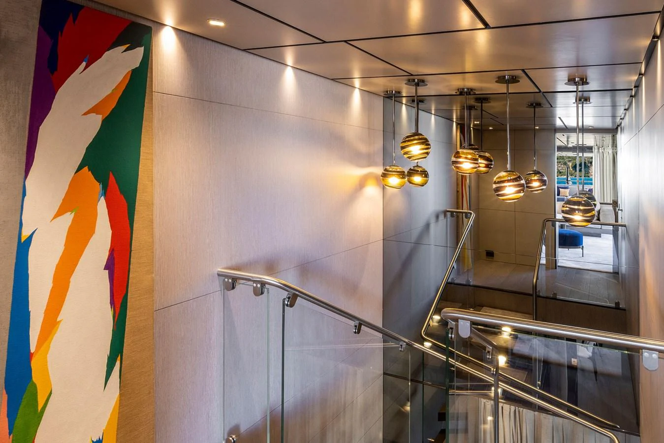 The yacht's interior features a modern stairwell with stylish lighting and contemporary artwork. aboard MIOTU Yacht for Sale