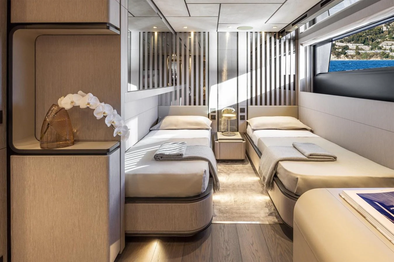 The twin stateroom features modern design with two single beds and ample natural light. aboard MIOTU Yacht for Sale