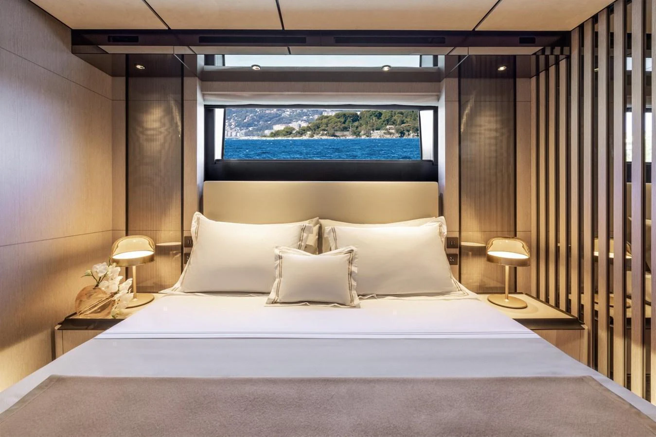 A luxurious stateroom with a large bed and a scenic view through the window. aboard MIOTU Yacht for Sale