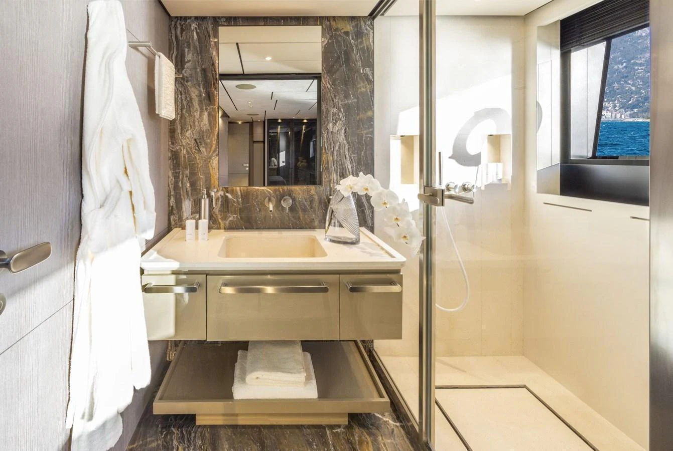 The yacht's bathroom features luxurious marble finishes and a spacious shower area with a view of the sea. aboard MIOTU Yacht for Sale