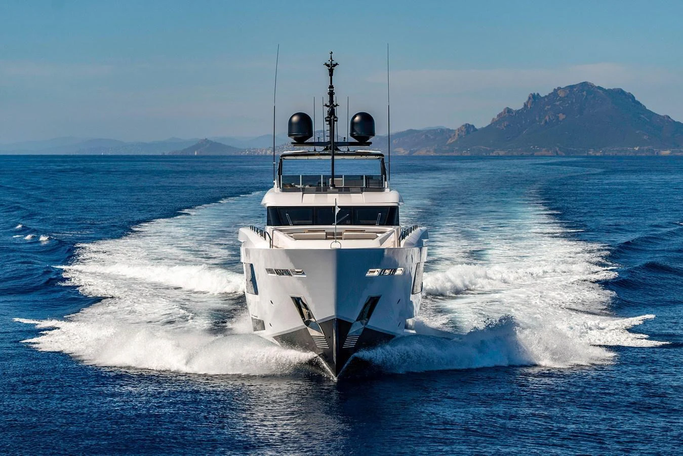 A sleek yacht cruises powerfully through the open sea, leaving a trail of white wake behind. aboard MIOTU Yacht for Sale