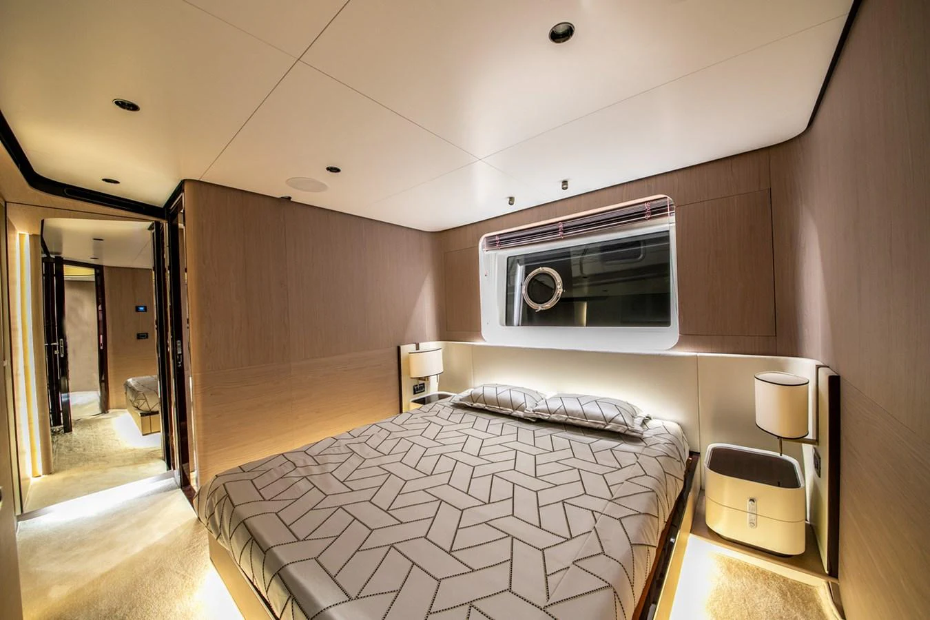 A luxurious stateroom featuring a comfortable bed with modern geometric bedding and ambient lighting. aboard NIRVANA BY THE SEA Yacht for Sale