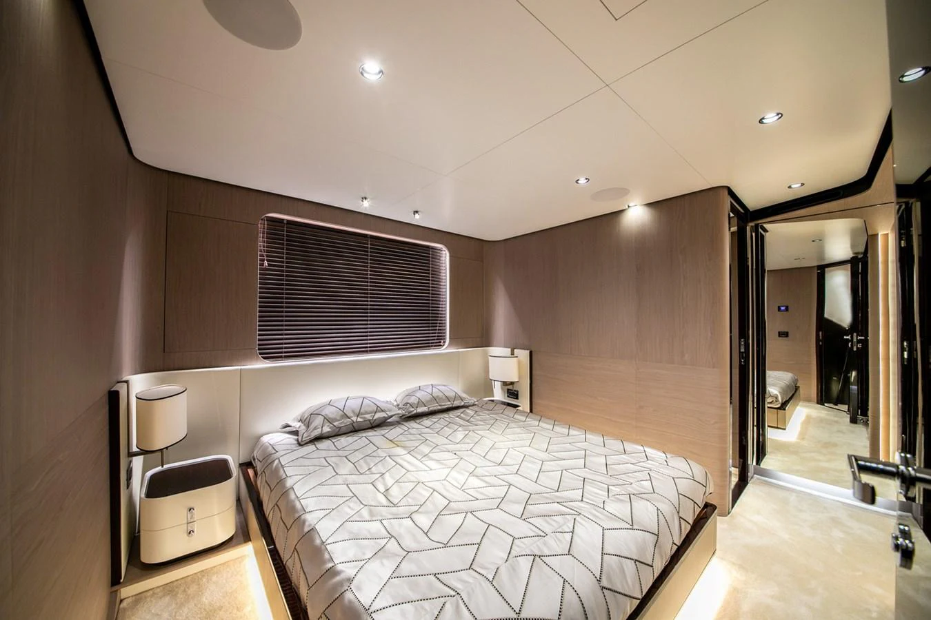 The stateroom features a modern design with a comfortable bed and ambient lighting. aboard NIRVANA BY THE SEA Yacht for Sale