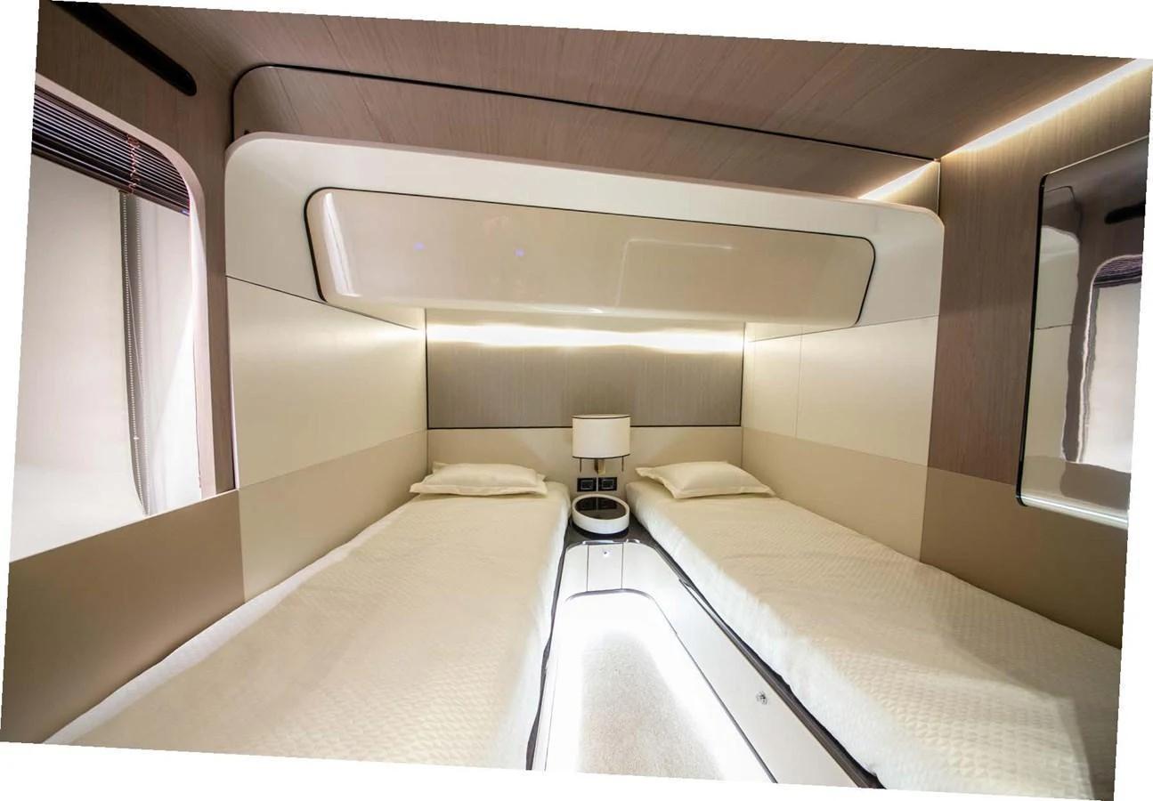 The twin stateroom features modern design with two single beds and ambient lighting. aboard NIRVANA BY THE SEA Yacht for Sale