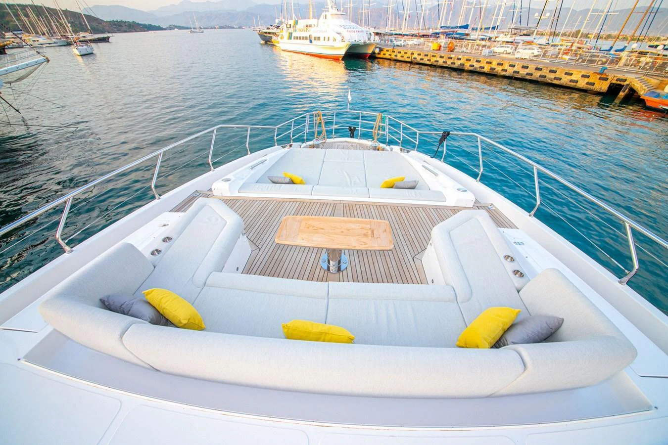 The foredeck of this yacht features a spacious seating area with plush cushions and a central table, perfect for relaxation and socializing. aboard NIRVANA BY THE SEA Yacht for Sale