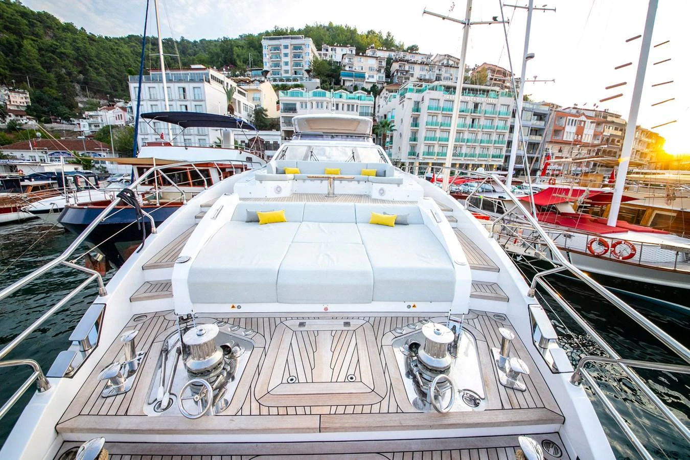 The foredeck features a spacious sunbathing area with plush white cushions and vibrant yellow pillows, perfect for relaxation. aboard NIRVANA BY THE SEA Yacht for Sale