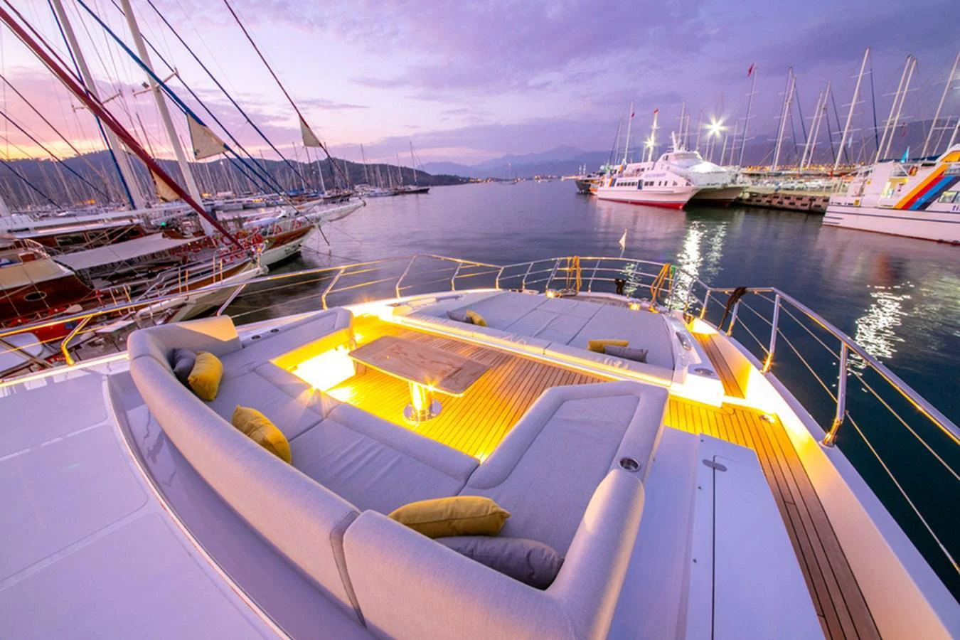 The yacht's aft deck offers a luxurious seating area with ambient lighting, perfect for evening relaxation. aboard NIRVANA BY THE SEA Yacht for Sale