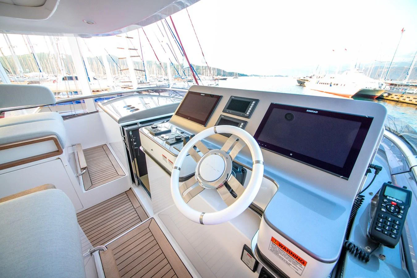 The helm station features modern navigation equipment and a sleek design. aboard NIRVANA BY THE SEA Yacht for Sale