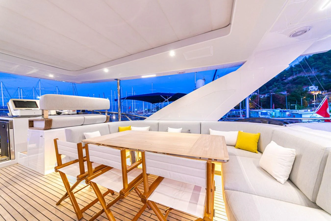 The aft deck features a comfortable seating area with a dining table, perfect for outdoor meals and relaxation. aboard NIRVANA BY THE SEA Yacht for Sale