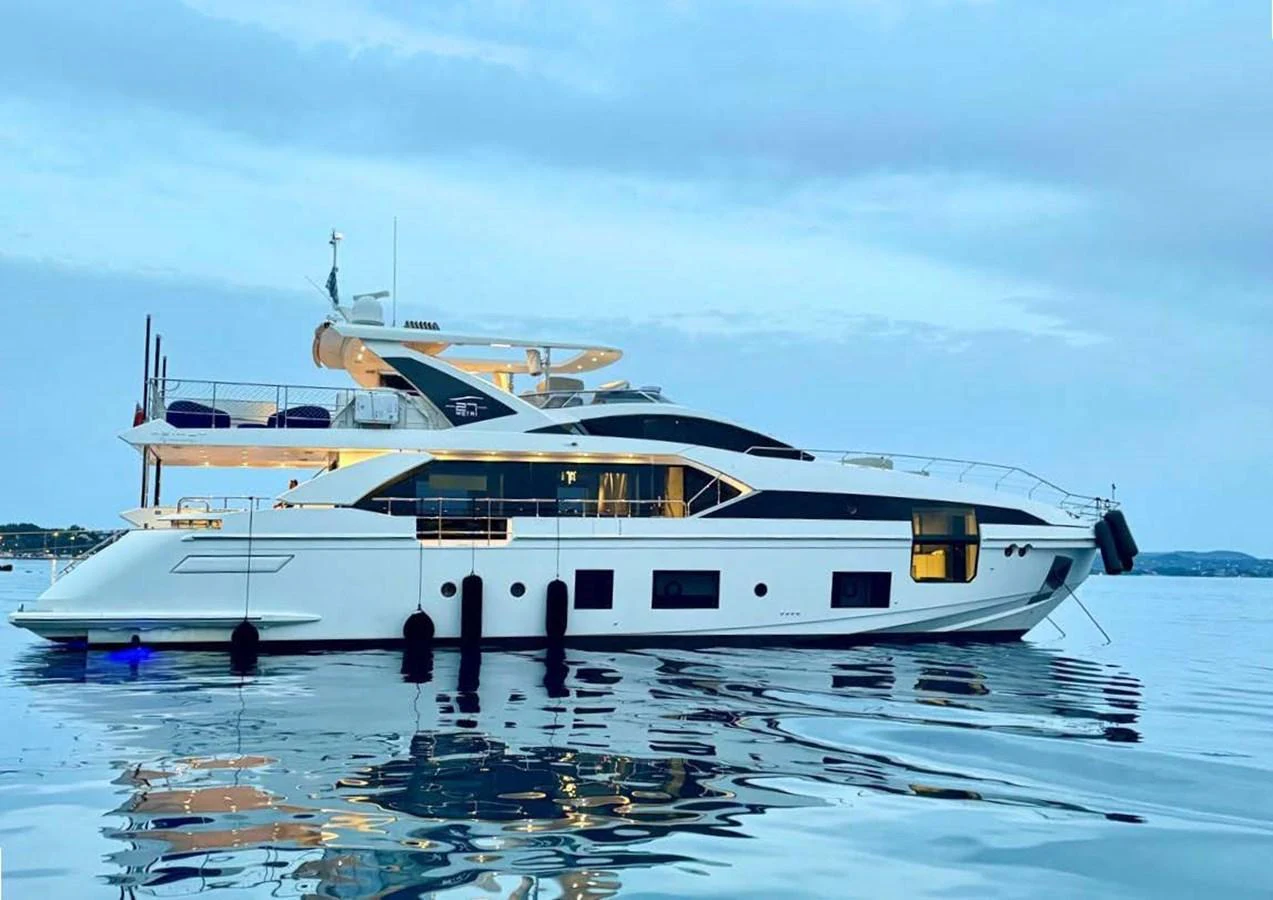 A sleek and modern yacht is anchored on calm waters during twilight, showcasing its elegant design and luxurious amenities. aboard NIRVANA BY THE SEA Yacht for Sale