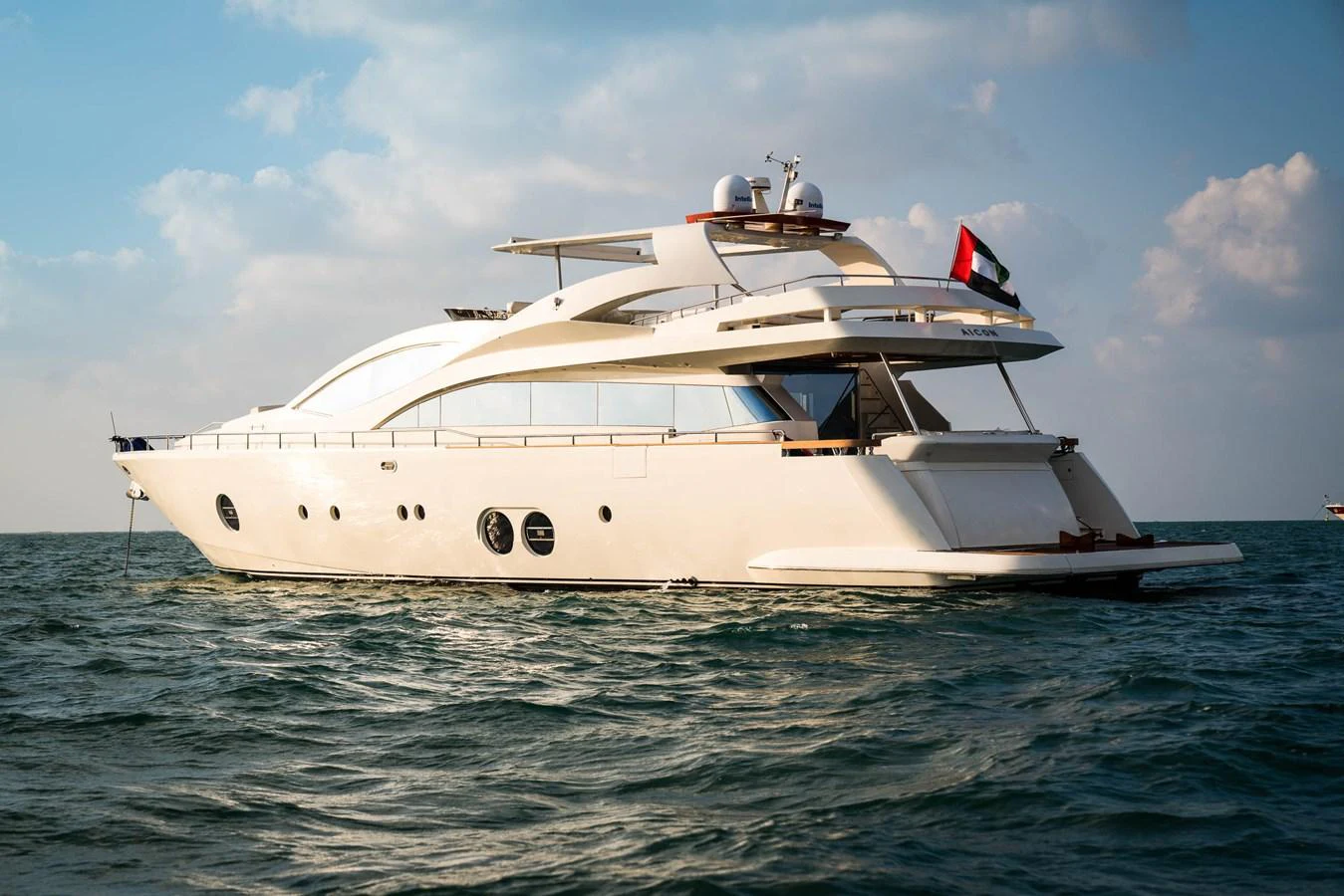 A sleek, modern yacht glides gracefully on the water under a clear sky. aboard TAYGET Yacht for Sale