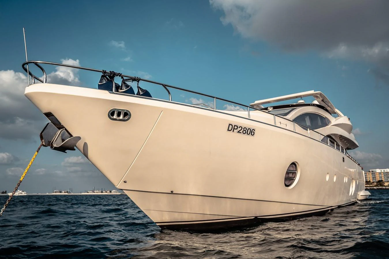 A sleek and modern yacht is anchored on calm waters under a partly cloudy sky. aboard TAYGET Yacht for Sale
