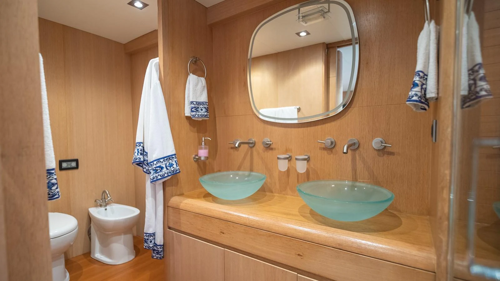 The yacht's bathroom features elegant twin glass sinks and modern fixtures. aboard TAYGET Yacht for Sale