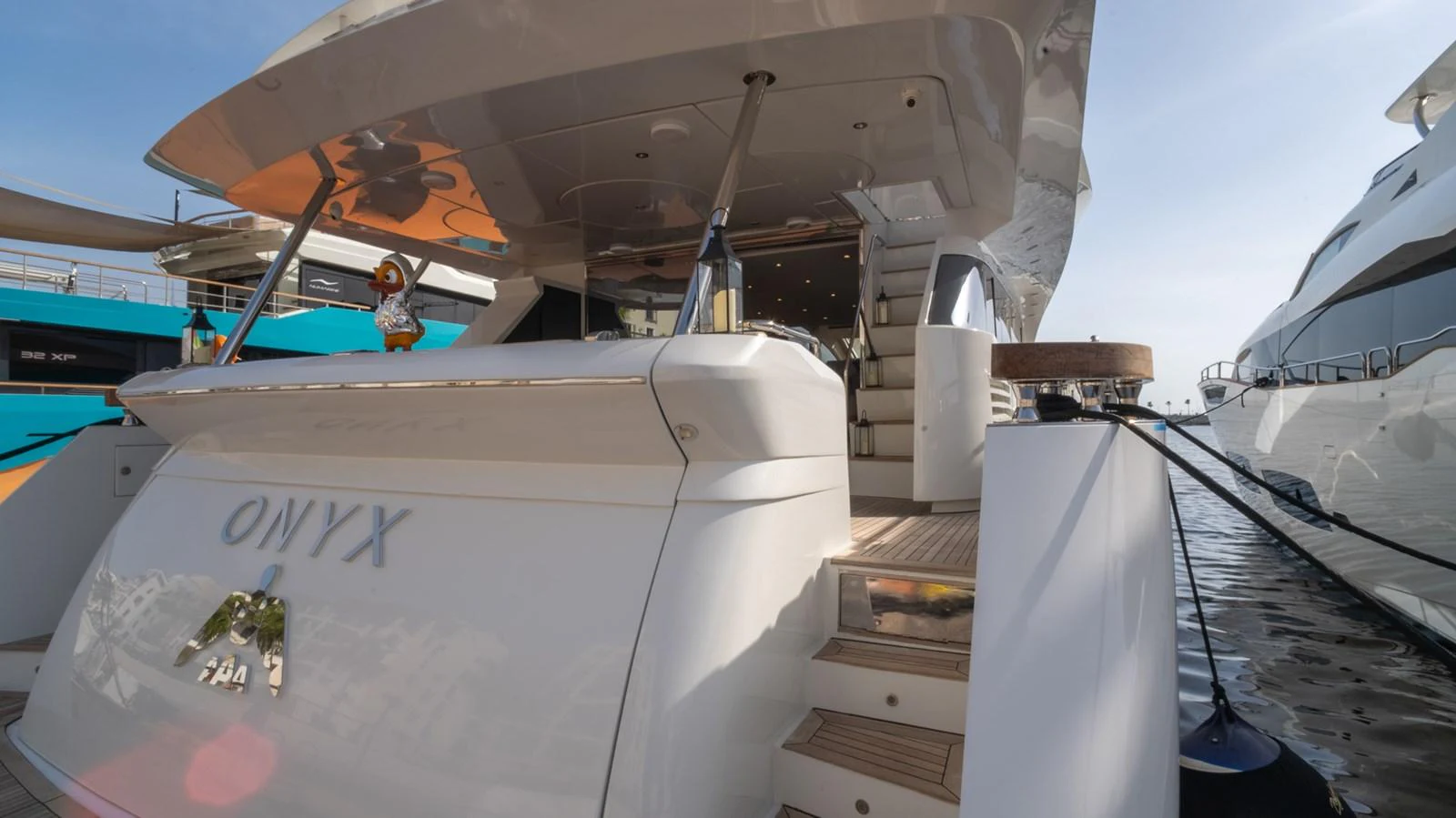 The yacht's aft deck features a spacious and inviting area with steps leading up to the main deck. aboard TAYGET Yacht for Sale