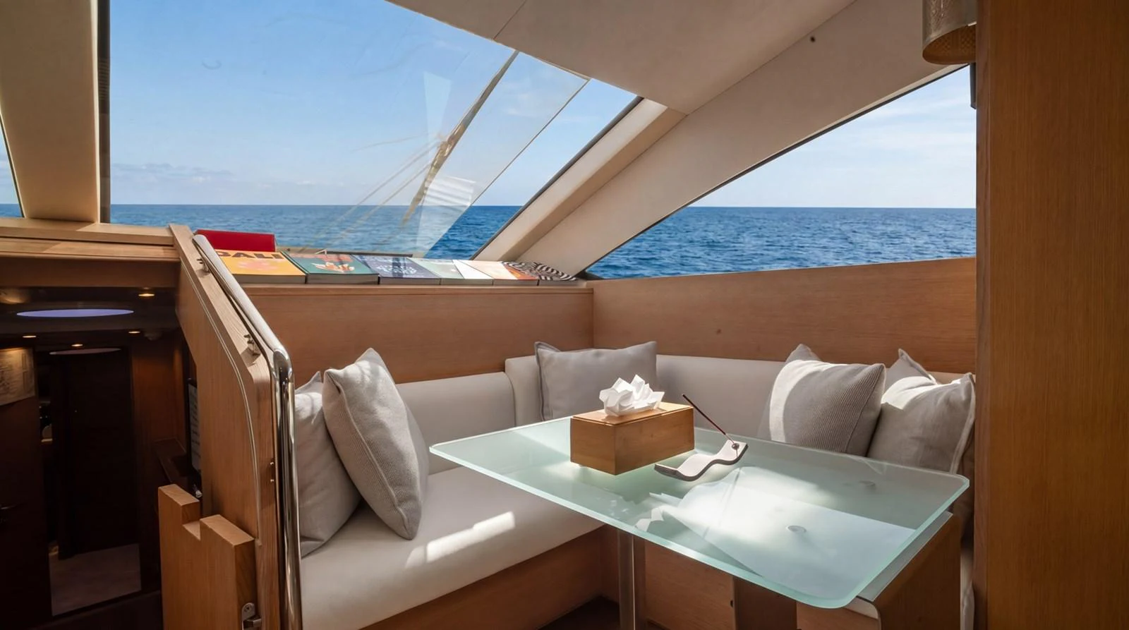 The salon features a cozy seating area with a glass table, offering stunning ocean views through large windows. aboard TAYGET Yacht for Sale