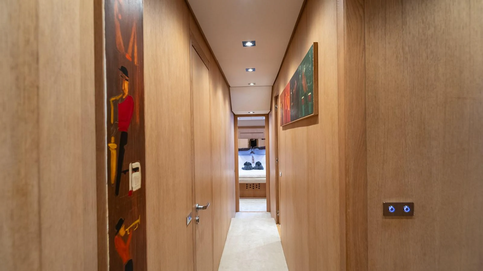 A well-lit hallway with wooden paneling leads to a cozy stateroom. aboard TAYGET Yacht for Sale