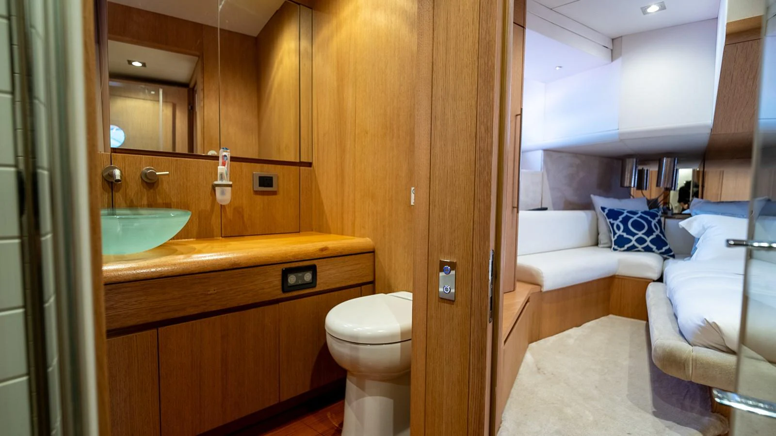 The image showcases a luxurious bathroom and stateroom with warm wooden finishes and modern amenities. aboard TAYGET Yacht for Sale
