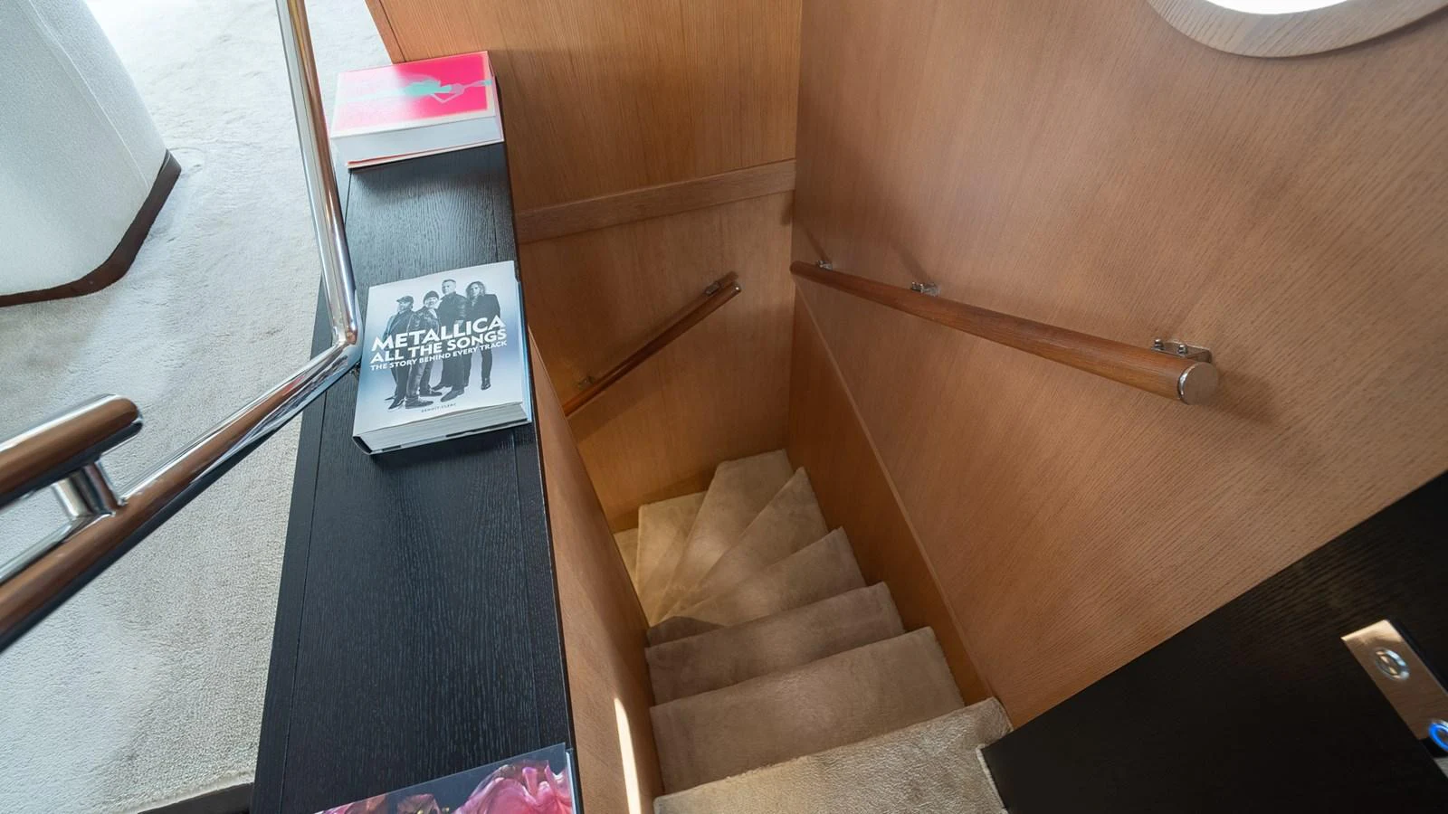 A cozy staircase with wooden paneling and carpeted steps leads to the lower deck. aboard TAYGET Yacht for Sale