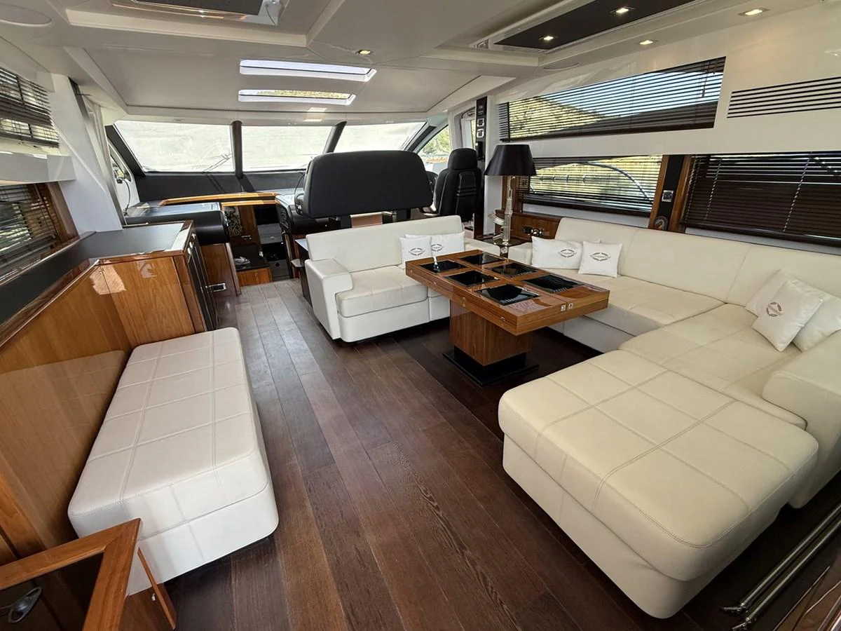 The salon features luxurious seating with ample natural light and elegant wooden accents. aboard M/Y TITAN Yacht for Sale