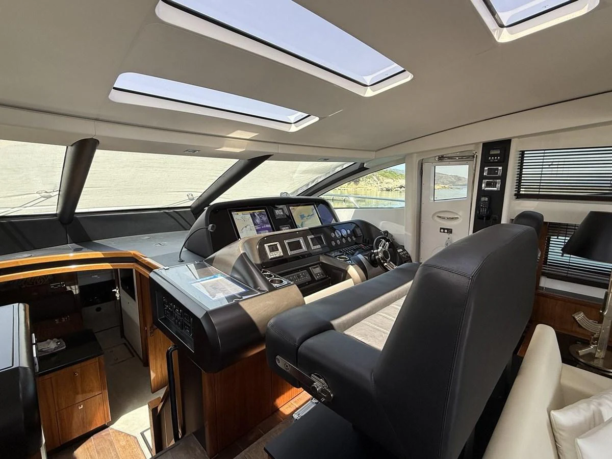 The helm station features modern navigation equipment and luxurious seating, bathed in natural light from overhead skylights. aboard M/Y TITAN Yacht for Sale