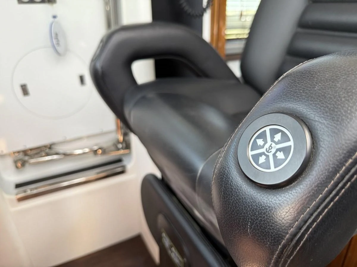 A close-up view of a luxurious black leather yacht chair with control buttons. aboard M/Y TITAN Yacht for Sale