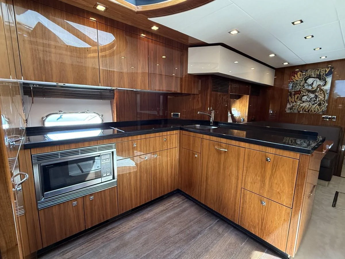 The galley features sleek wooden cabinetry, modern appliances, and ample counter space. aboard M/Y TITAN Yacht for Sale
