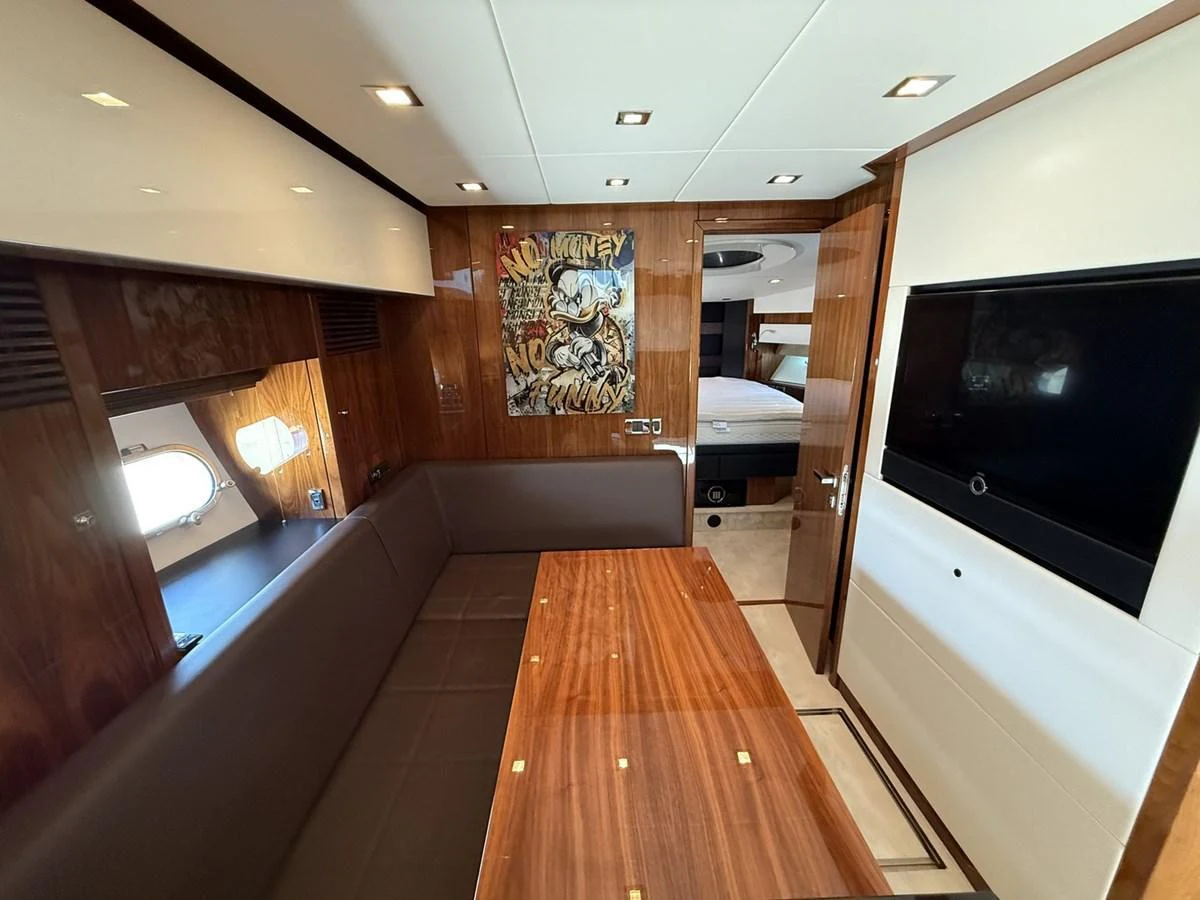 The yacht's salon features a cozy seating area with a polished wooden table and modern decor. aboard M/Y TITAN Yacht for Sale