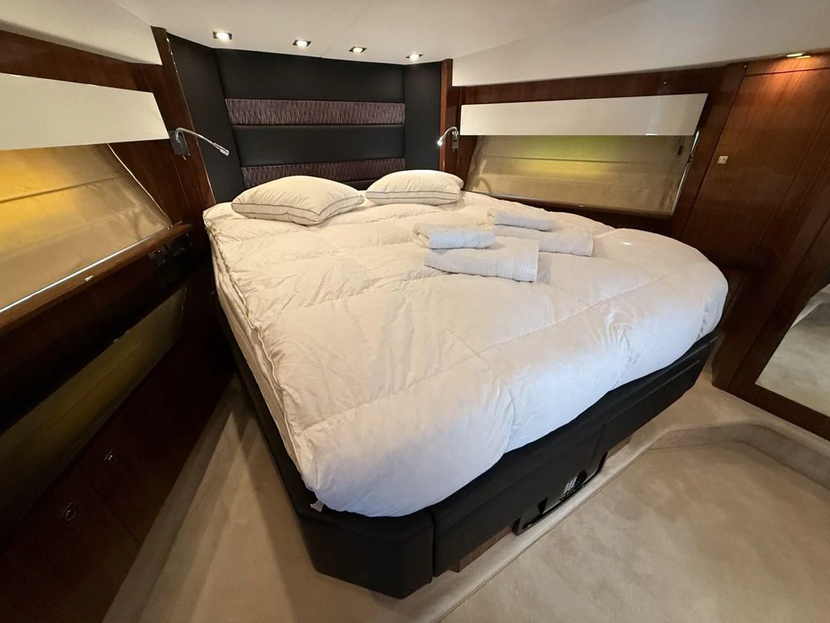The stateroom features a plush double bed with luxurious bedding and warm ambient lighting. aboard M/Y TITAN Yacht for Sale