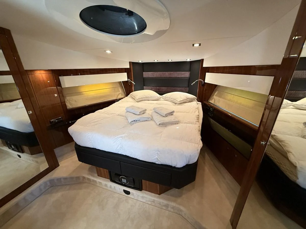 The master stateroom features a luxurious bed with plush linens and elegant wood paneling. aboard M/Y TITAN Yacht for Sale