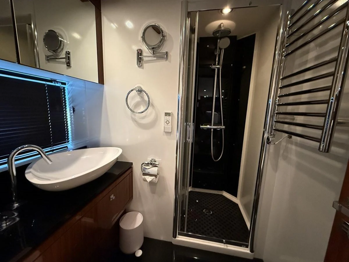 The yacht's bathroom features a sleek shower, modern sink, and elegant fixtures. aboard M/Y TITAN Yacht for Sale