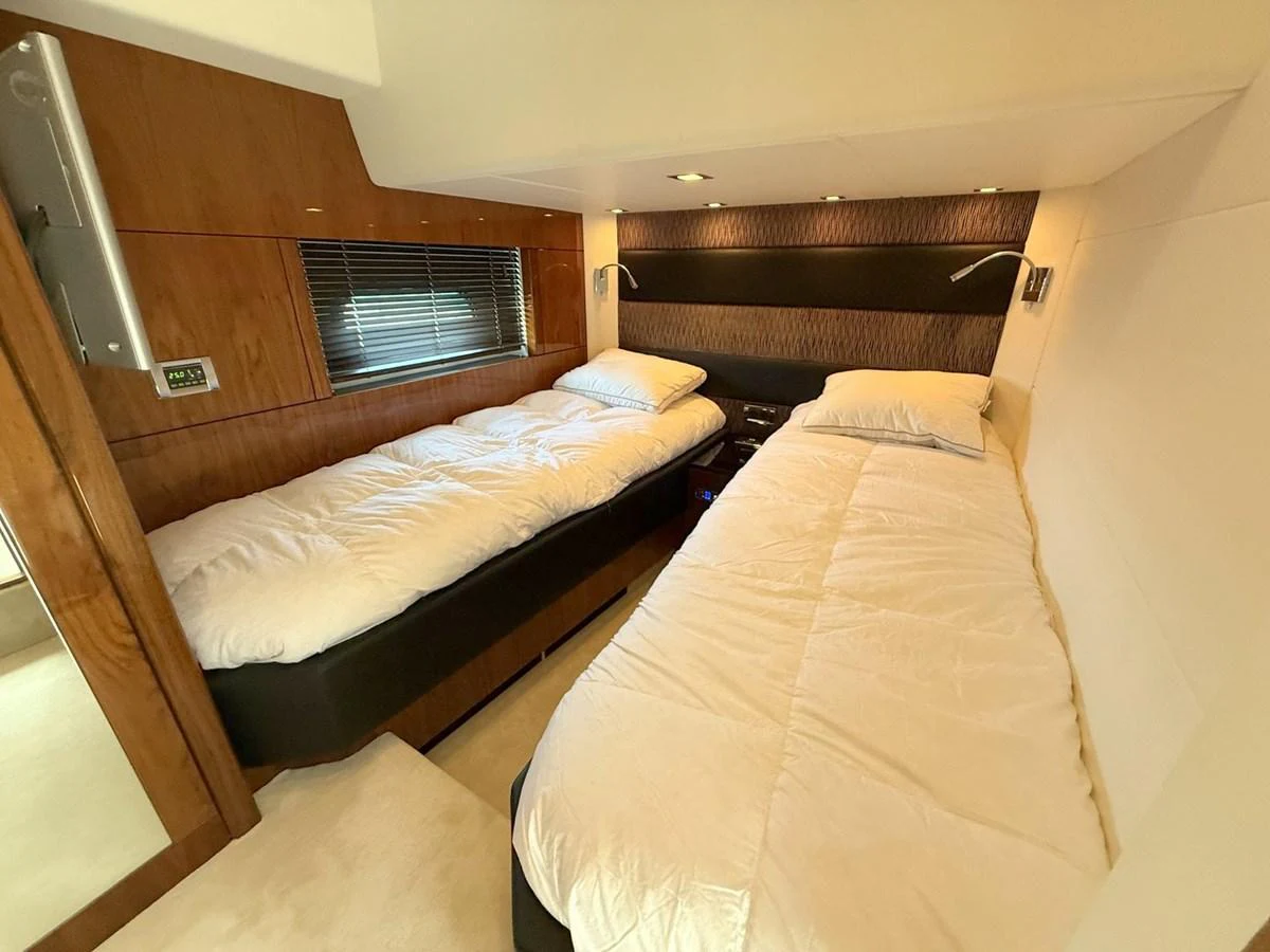 The guest cabin features two comfortable twin beds with modern lighting and wood accents. aboard M/Y TITAN Yacht for Sale