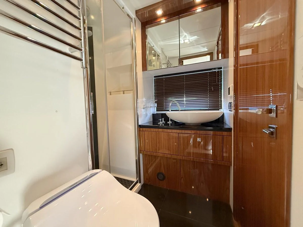 The yacht's bathroom features a sleek design with a modern sink and wooden cabinetry. aboard M/Y TITAN Yacht for Sale
