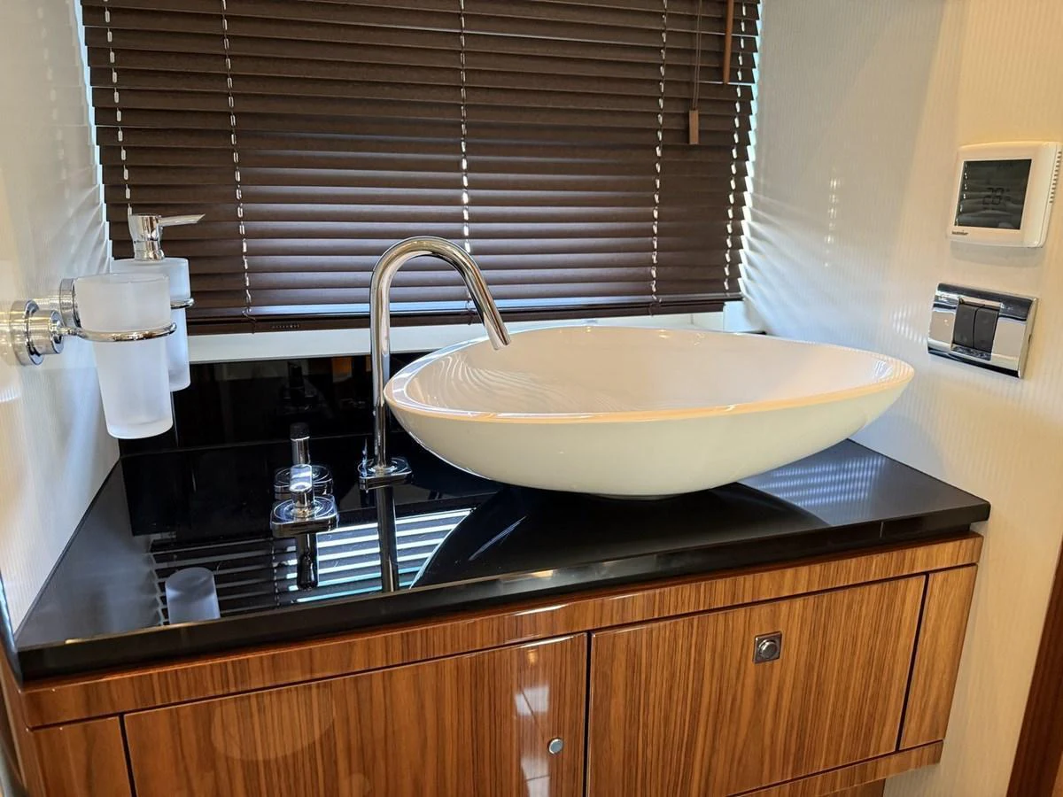 A stylish bathroom with a modern sink and wooden cabinetry. aboard M/Y TITAN Yacht for Sale