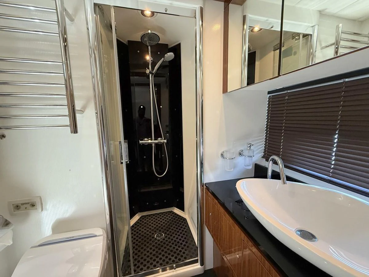 The yacht's bathroom features a sleek shower, modern sink, and elegant finishes. aboard M/Y TITAN Yacht for Sale