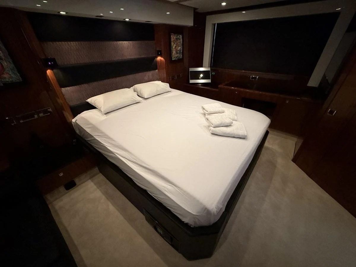 The master stateroom features a spacious bed and elegant wood paneling. aboard M/Y TITAN Yacht for Sale