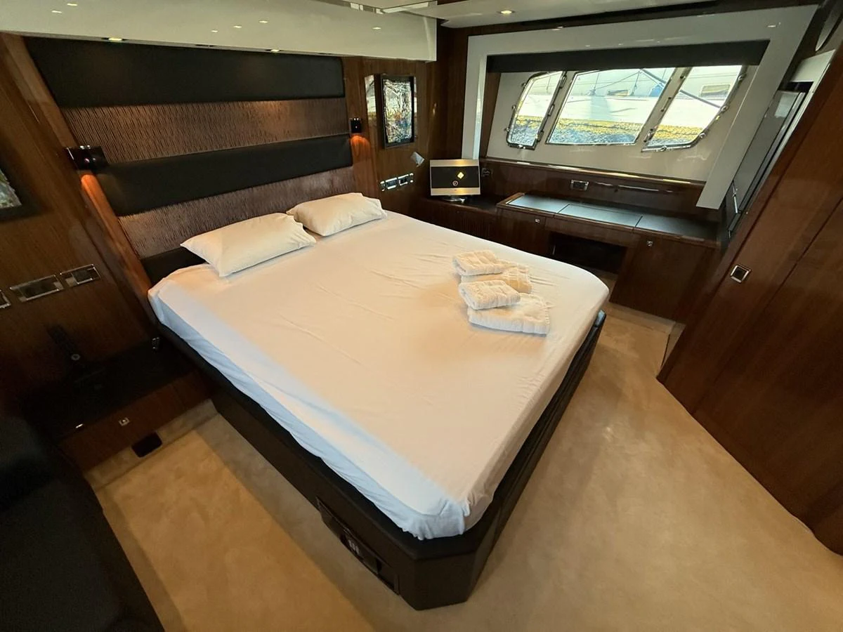 The master stateroom features a luxurious bed with plush linens and ample natural light from large windows. aboard M/Y TITAN Yacht for Sale