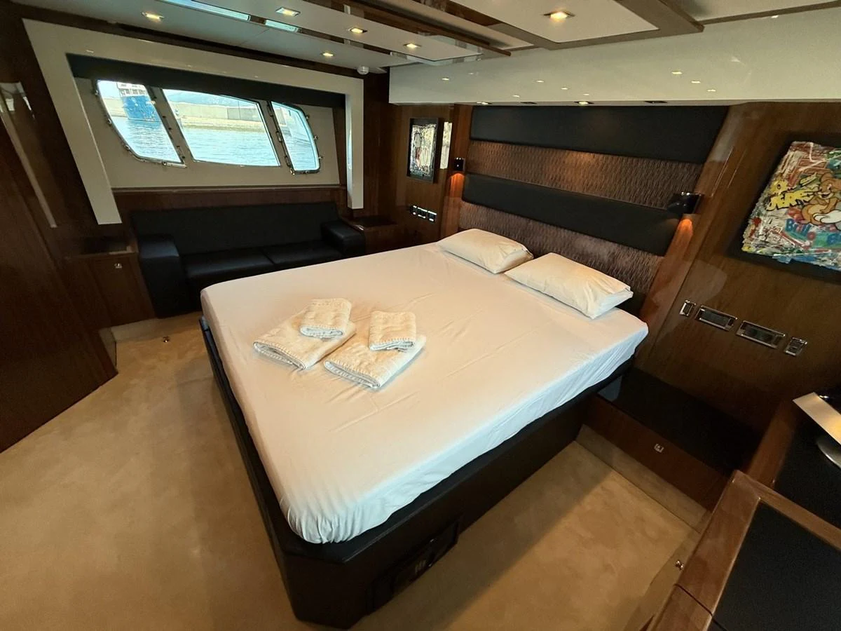 The stateroom features a comfortable bed with luxurious linens and ample natural light from large windows. aboard M/Y TITAN Yacht for Sale
