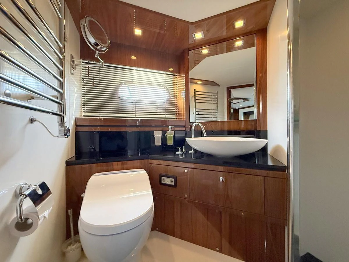 The yacht's bathroom features elegant wood paneling and modern fixtures, creating a luxurious and comfortable space. aboard M/Y TITAN Yacht for Sale