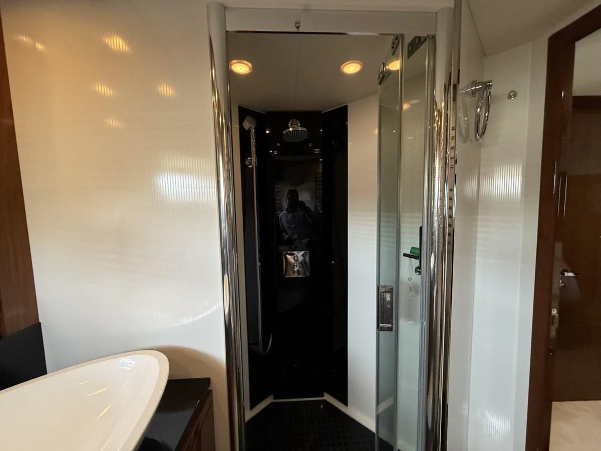 The yacht's bathroom features a modern shower with sleek glass doors and elegant fixtures. aboard M/Y TITAN Yacht for Sale