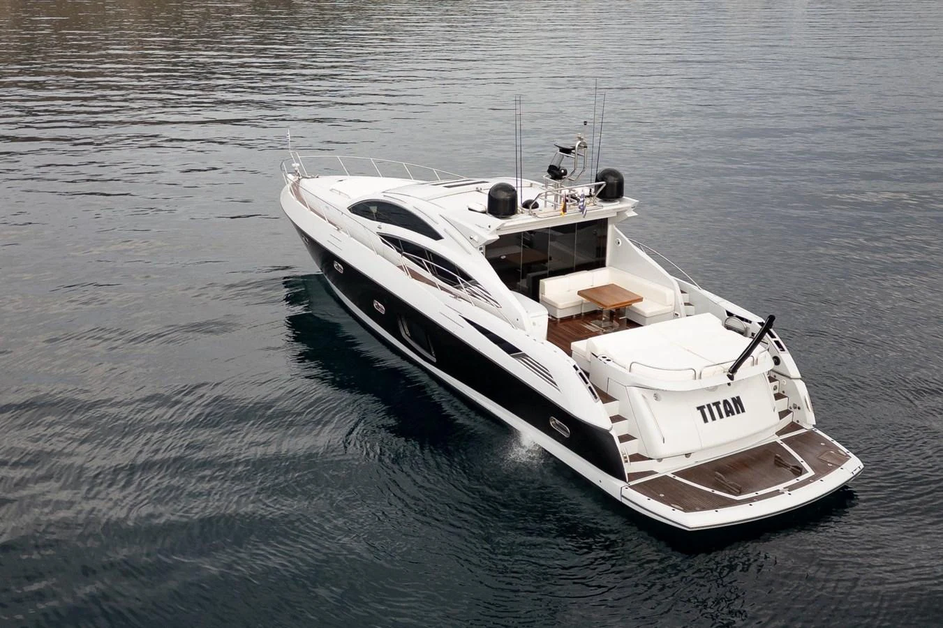 A sleek and modern yacht glides gracefully on calm waters, showcasing its elegant design and spacious aft deck. aboard M/Y TITAN Yacht for Sale