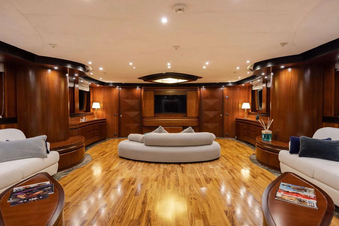 The yacht's salon features elegant wood paneling, plush seating, and a large flat-screen TV for entertainment. aboard HOLIDAY Yacht for Sale